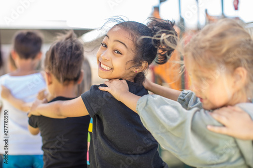 Happy children making a conga line in kindergarten photo