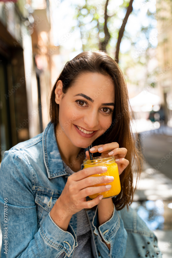 Young woman holding glass with fresh juice