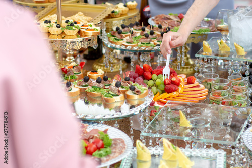 Large selection of food with cold snacks, meat and salads, fruit, cold meats, cheese and jam served. Variety of tasty delicious snacks on the table.