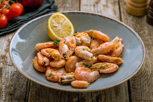 boiled shrimp on plate on wooden background