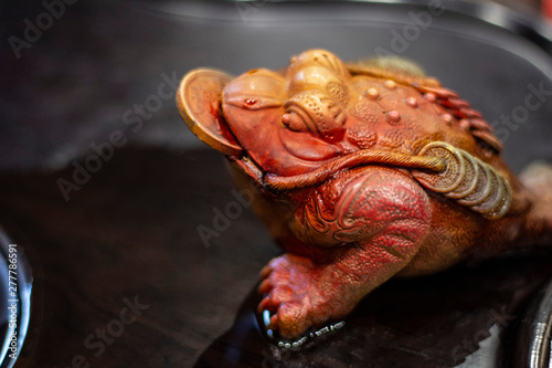 Red brown brown ceramic tea frog on a black wooden table for a tea ceremony