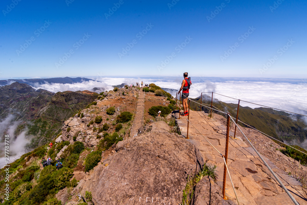 Group of hikers admiring view at Pico Ruivo peak, Madeira, Portugal.