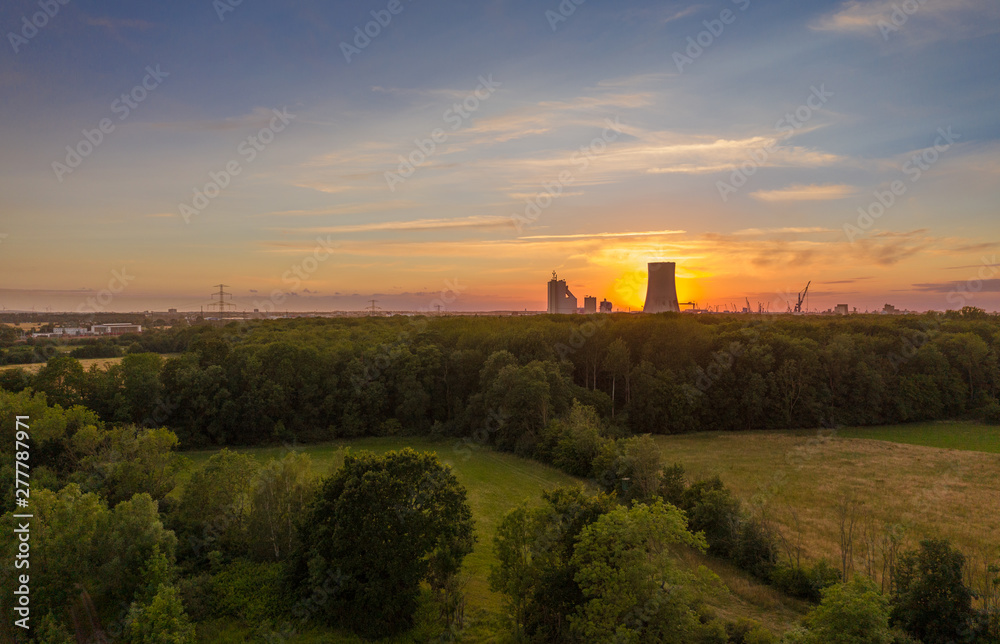 sunset over field with power plant in the background sunset over field with power plant in the background