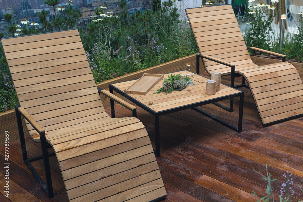 Natural wooden armchairs on patio for relaxation. Interior