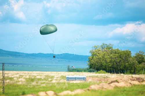 A military crate is being parachuted from a military cargo plane during a drill. photo