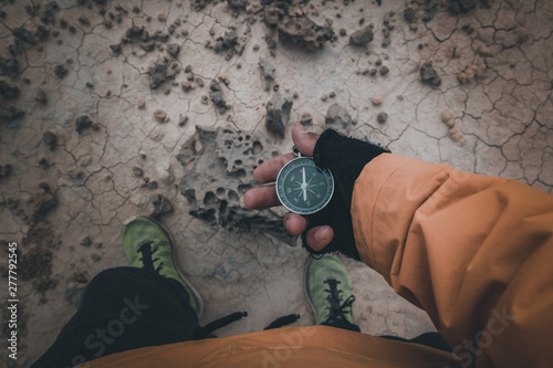 Compass in hand on dry desert area photo