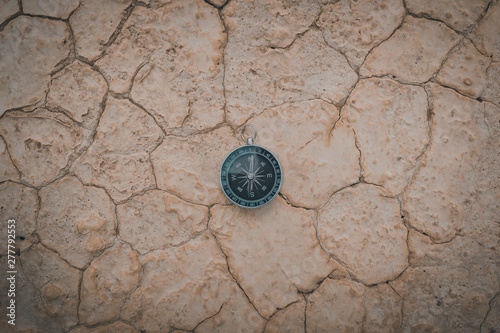 Big compass on dry cracked desert area photo