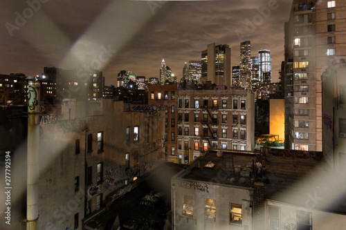 Manhattan bridge view over Chinatown at night, lower Manhattan in the background. New York City, United States of America.