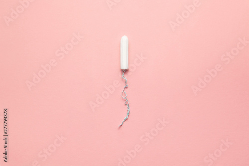 Unpacked small size tampon on a soft pink background. Modern female intimate gynecological hygiene. Eco zero waste concept. Copy spase place for text. Flat lay © Val Mad