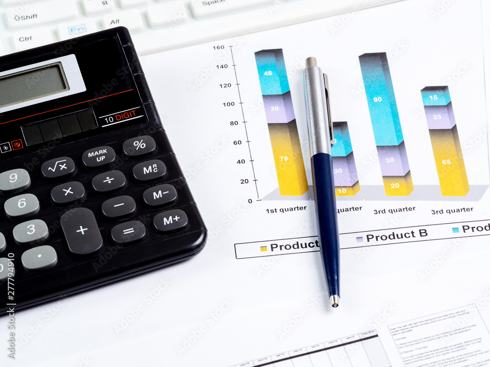 Calculator, pen on the background of graphic charts Calculator, pen on the background of graphic charts