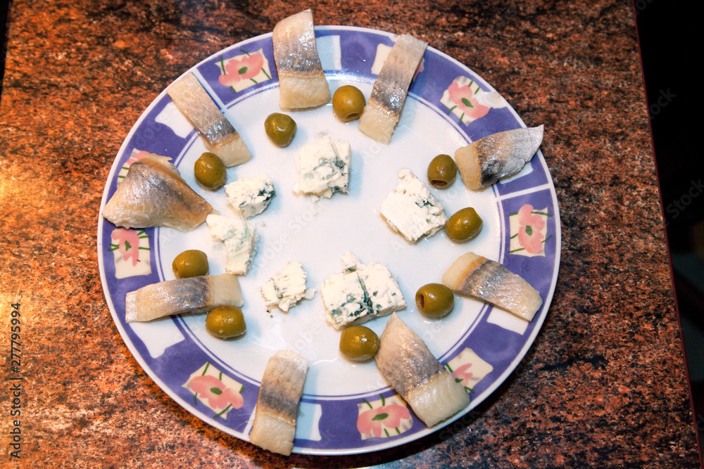 Polish hors d'oeuvre snack plate with circle of herring fish, blue cheese, and green olives. Zawady Poland