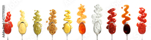 Set of spoons with different delicious sauces on white background, top view