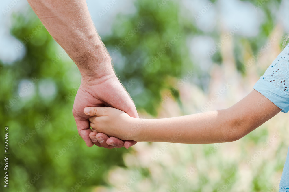 cropped view of father holding hands with daughter cropped view of father holding hands with daughter