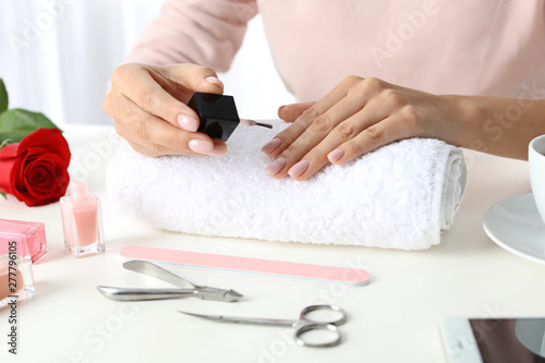 Woman applying nail polish at table, closeup. At-home manicure © New Africa