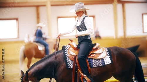 Cowgirl ride horse one-handed in slow motion photo