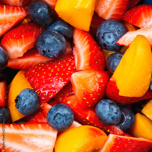 Fotografie Close up top down view of a colorful bowl of mixed fruit salad with bite sized p