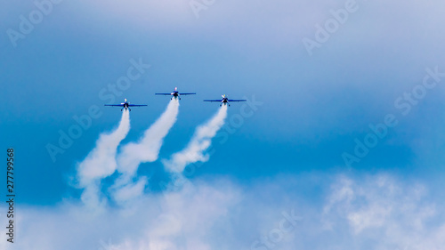 3 performance jets, flying in tandem, on a blue sky with white clouds