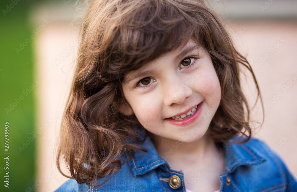 Cute curly haired girl in blue jeans shirt with beautiful brown eyes smiling Cute curly haired girl in blue jeans shirt with beautiful brown eyes smiling