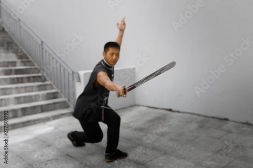 A young athlete engaged in Wushu in the city. Training with a sword. © ProstoSvet
