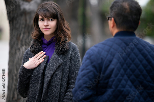 Woman walking outdoors in the city and looking snobby while running into an ex boyfriend or looking annoyed by an insulting stranger.  It also depicts social anxiety. photo