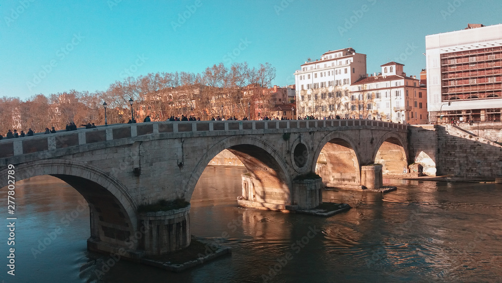 personas cruzando un puente de la ciudad de Roma 