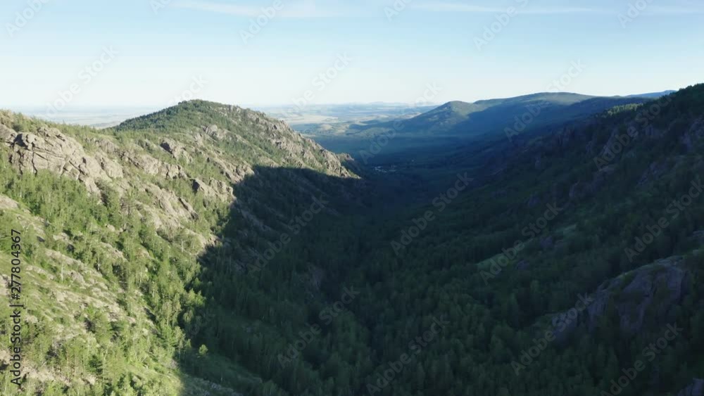 In the middle of the canyon.Aerial follow panoramic shot.The camera flies between the mountains.