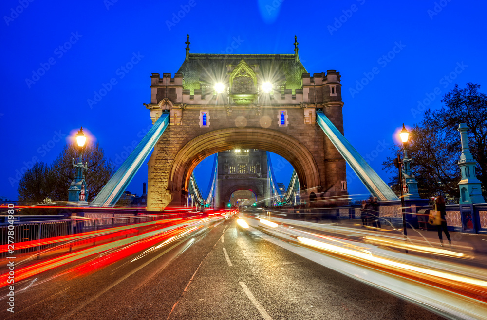 Obraz premium Vehicles pass over Tower Bridge across the River Thames in London, UK.