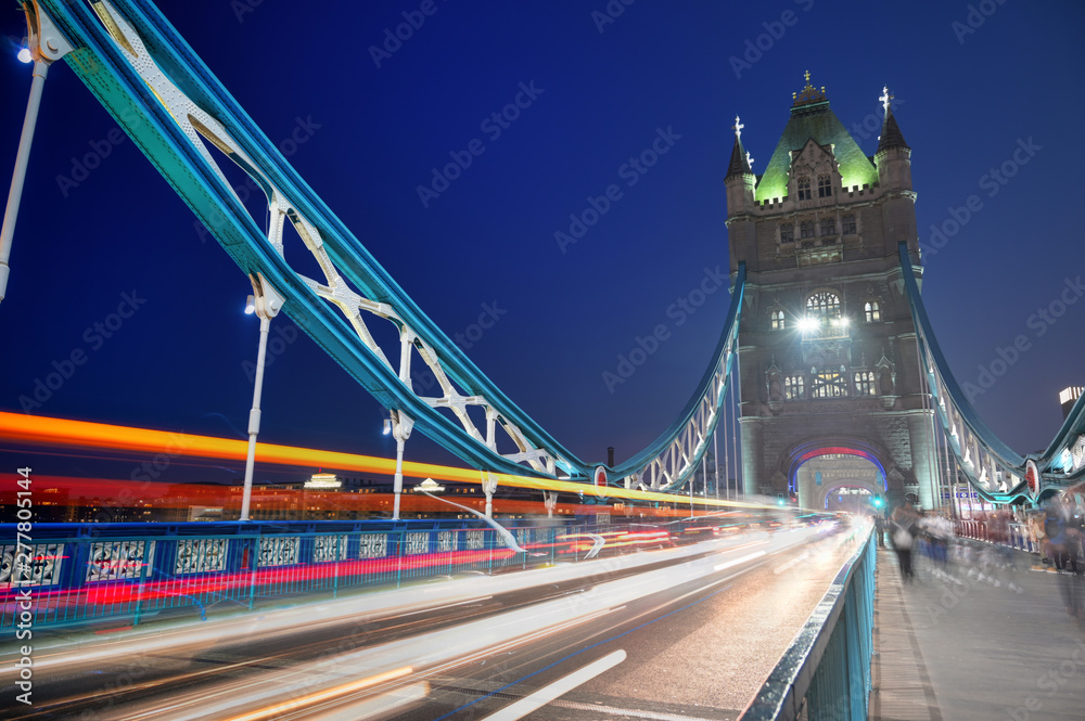 Obraz premium Vehicles pass over Tower Bridge across the River Thames in London, UK.