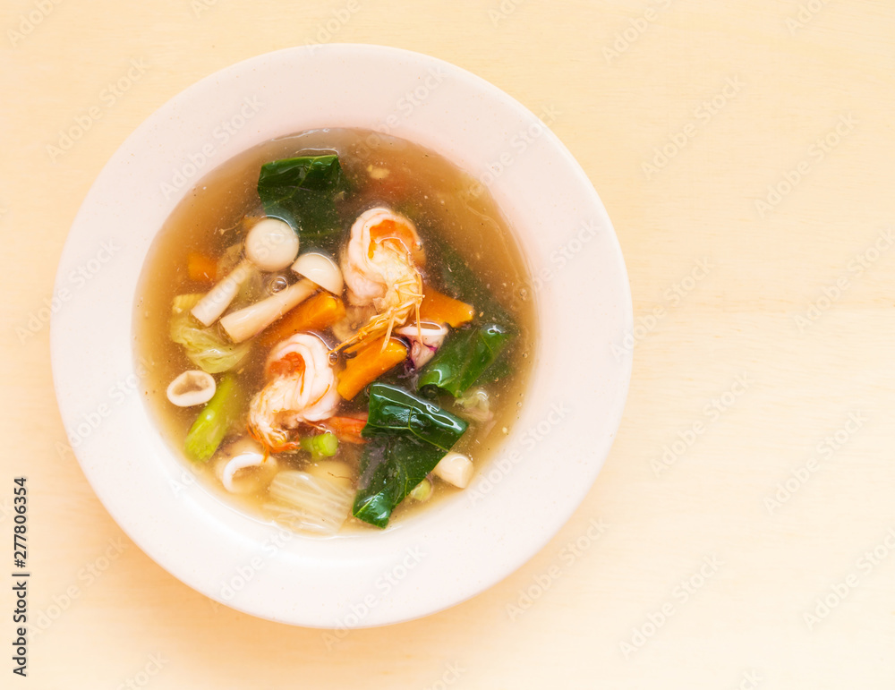 Seafood soup with prawn squid and vegetable in bowl on wooden background. Seafood soup with prawn squid and vegetable in bowl on wooden background.