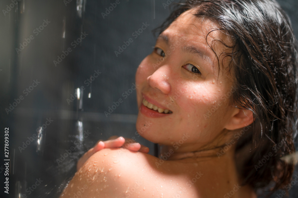 young beautiful and happy Asian Chinese woman 20s to 30s wet and fresh smiling cheerful taking a shower feeling relaxed with shampoo in her hair