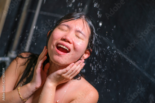 young beautiful and happy Asian Chinese woman 20s to 30s wet and fresh smiling cheerful taking a shower feeling relaxed with shampoo in her hair