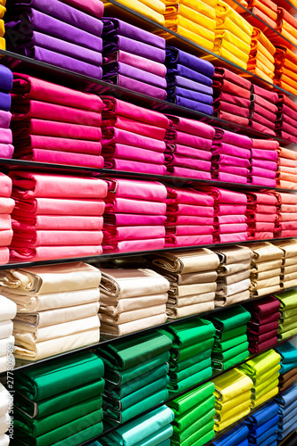 Colorful clothing neatly stacked on shelves 