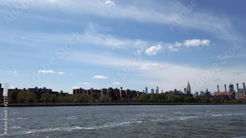 View of Manhattan skylineand Empire State Building from ferry on East River NYC.