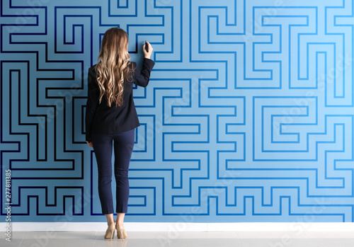Woman in formal clothes drawing on color wall. Concept of business plan development photo