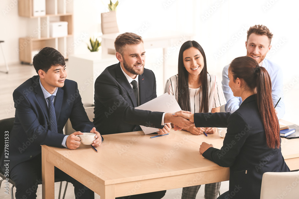 Human resources manager shaking hands with applicant after successful interview Human resources manager shaking hands with applicant after successful interview