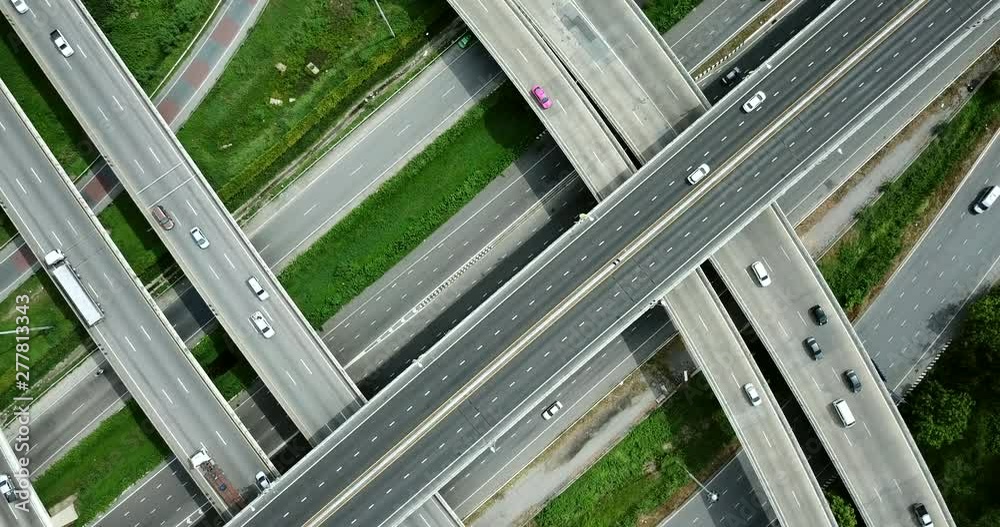 4K. Aerial view of road interchange of highway intersection with busy urban traffic speeding on the road. Junction network of transportation taken by drone. 4K. Aerial view of road interchange of highway intersection with busy urban traffic speeding on the road. Junction network of transportation taken by drone.