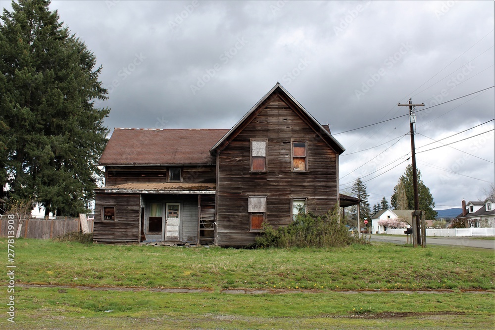 Fototapeta premium Abandoned house in Granite Falls, WA (side view) with a concrete arch in the front yard