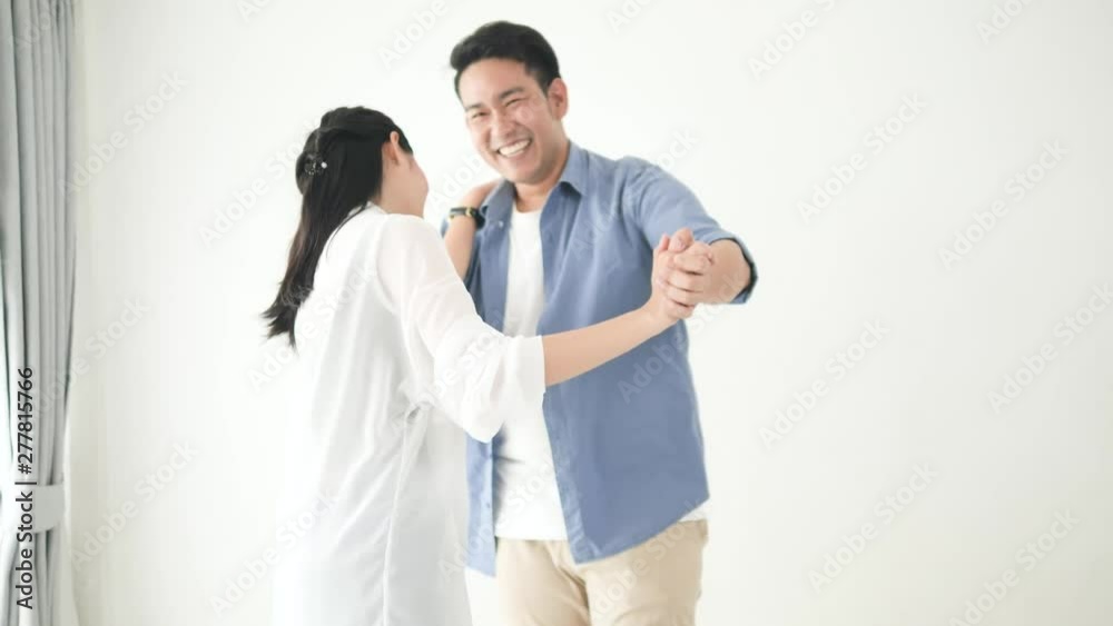 Happy Asian couple dancing together at home, slow motion. Happy Asian couple dancing together at home, slow motion.