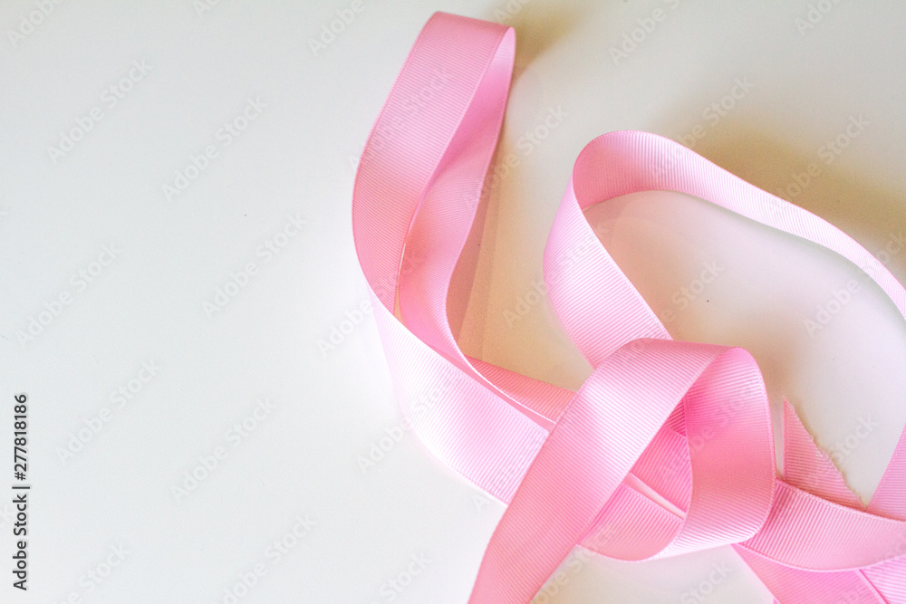 Pink ribbon on white background. Valentine's day, March 8, women's day, Birthday, mother's Day, New year. The view from the top. Background for greeting cards and illustrations. Gift wrapping Pink ribbon on white background. Valentine's day, March 8, women's day, Birthday, mother's Day, New year. The view from the top. Background for greeting cards and illustrations. Gift wrapping