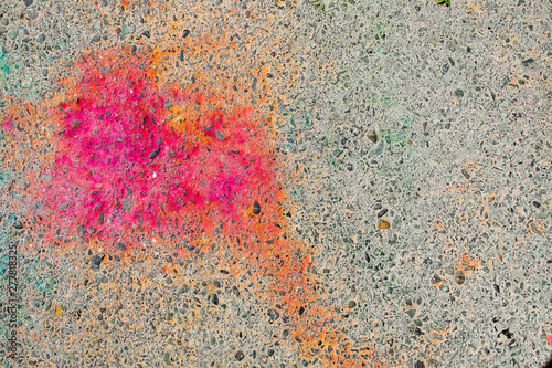 Colorful asphalt after festival of colors Holi. Red spot. Asphalt background