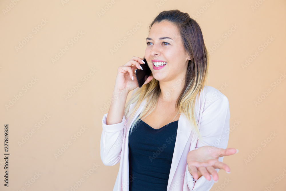 Puzzled joyful lady talking on mobile phone and shrugging shoulders. Confused young woman speaking on cellphone and answering she having no idea. Phone conversation concept Puzzled joyful lady talking on mobile phone and shrugging shoulders. Confused young woman speaking on cellphone and answering she having no idea. Phone conversation concept