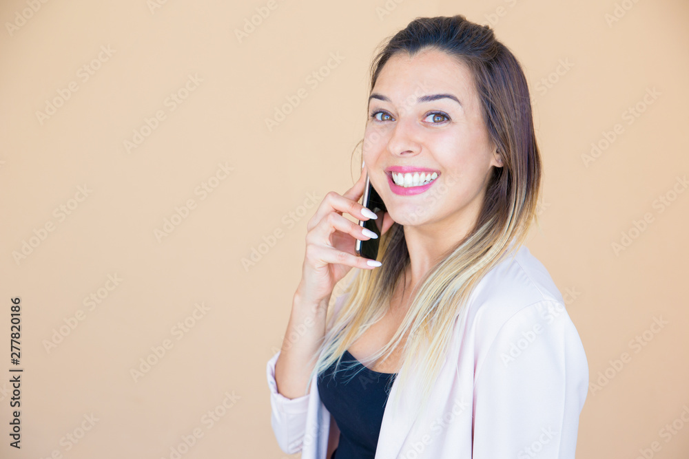 Happy excited lady enjoying phone talk. Joyous young woman in white casual jacket calling on cellphone and smiling at camera. Good news concept Happy excited lady enjoying phone talk. Joyous young woman in white casual jacket calling on cellphone and smiling at camera. Good news concept