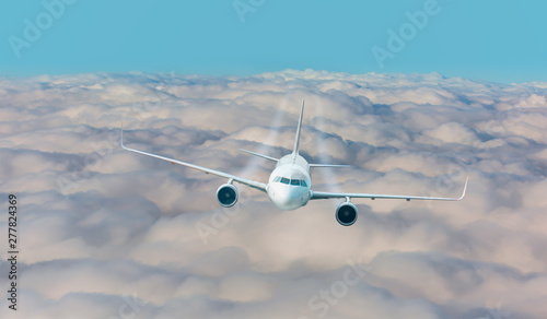Passenger airplane jet flying over low clouds and city