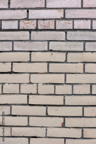 Old painted beige color weathered stained brick wall