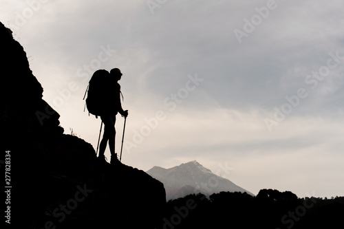 Silhouette of female hiker standing on mountain