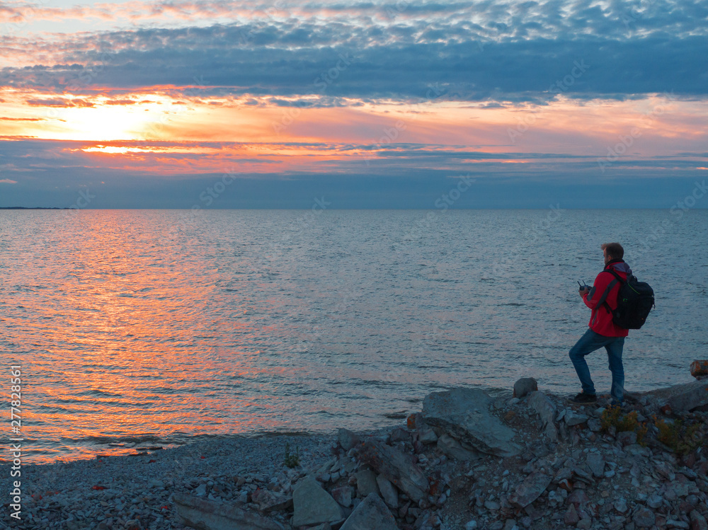 Fototapeta premium man at sunset by the sea.