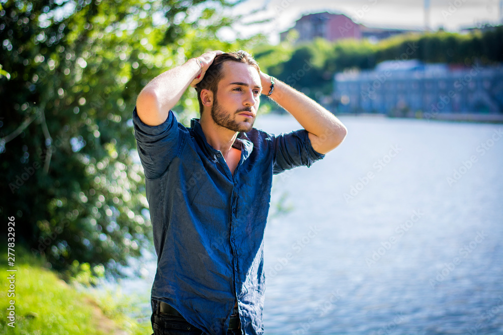 One handsome young man in urban setting in European city, Turin in Italy by the river Po One handsome young man in urban setting in European city, Turin in Italy by the river Po