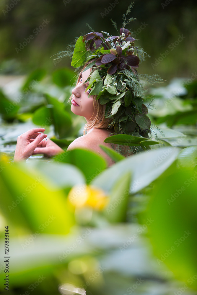 Obraz premium beautiful sexy woman bathes in a lake with water lilies