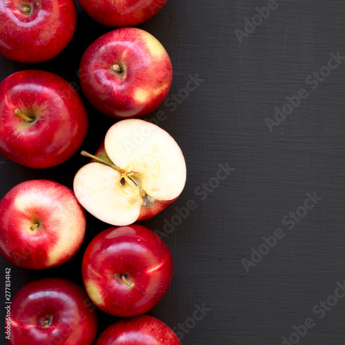 Overhead view, fresh raw red apples on a black background. Flat lay, top view, from above. Copy space.