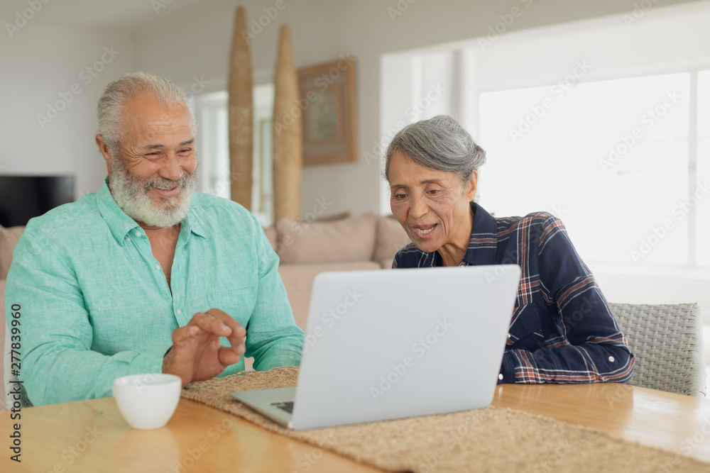 Couple using laptop on table inside a room Couple using laptop on table inside a room